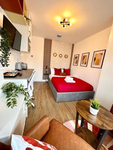a hotel room with a red bed and a table at Newly renovated Private Self contained Room in Selly Oak Birmingham with bathroom shared between two rooms R1 in Birmingham