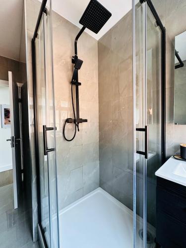 a shower with a glass shower stall in a bathroom at Newly renovated Private Self contained Room in Selly Oak Birmingham with bathroom shared between two rooms R1 in Birmingham