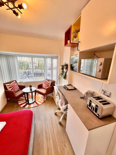 a kitchen with a counter and a living room at Newly renovated Private Self contained Room in Selly Oak Birmingham with bathroom shared between two rooms R1 in Birmingham