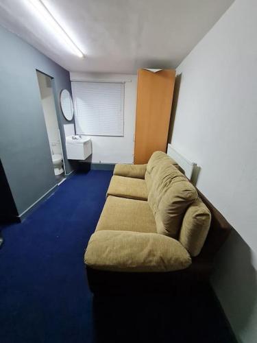 ein Wohnzimmer mit einem Sofa in der Ecke eines Zimmers in der Unterkunft Room near East Midland Airport Room 6 in Kegworth