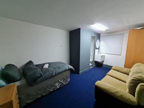 sala de estar con sofá y cama en Room near East Midland Airport 6 en Kegworth