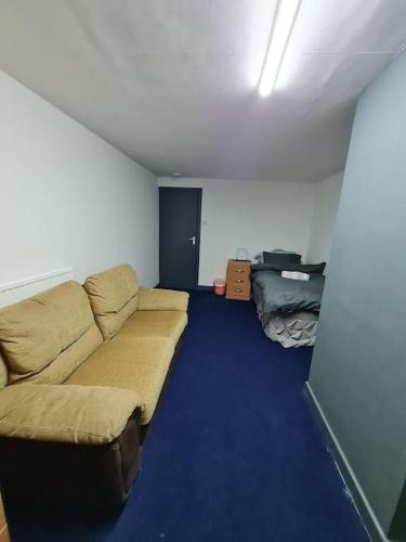 a living room with a couch and a blue carpet at Room near East Midland Airport Room 6 in Kegworth