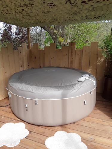 a hot tub in a backyard with a wooden fence at Un week-end à la campagne in Pont-Audemer