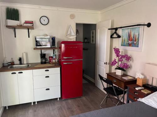 a red refrigerator in a kitchen with a desk at Lovely Studio Apartment with Kitchenette. in Tampa