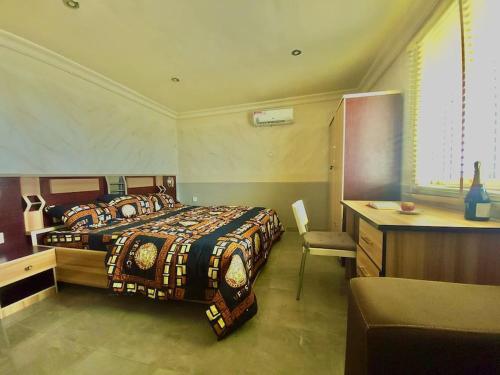 a bedroom with a bed and a desk and a bed sidx sidx sidx at Quiet Apartment in Redemption Camp, Ogun State in Pakuro