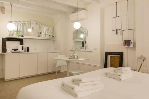 um quarto branco com toalhas em cima de uma cama em PUNTO FERMO in Verona center 023091-LOC-01911 em Verona