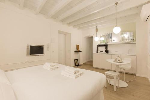 um quarto branco com uma cama branca e uma mesa em PUNTO FERMO in Verona center 023091-LOC-01911 em Verona