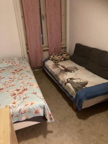 ein Schlafzimmer mit zwei Betten und einem Sofa darin in der Unterkunft Rivas in Tyresö