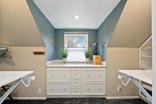 a bathroom with white cabinets and a window at Hand House in Boise
