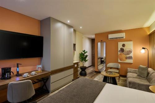 a hotel room with a television and a living room at Blues Suites Medellín in Medellín