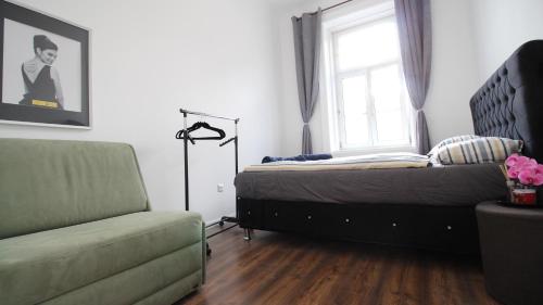 een slaapkamer met een bed, een raam en een stoel bij Spacious Apartment in Liesing Area LV5 in Wenen