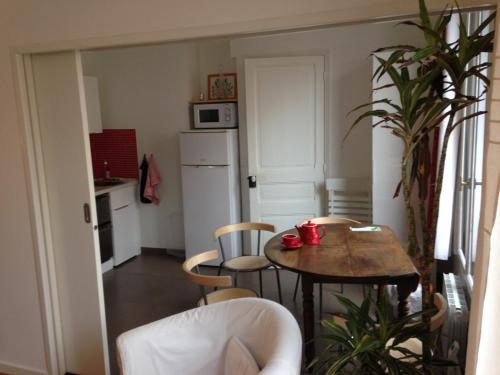 une cuisine avec une table et des chaises dans une pièce dans l'établissement Appartement Comme Une Petite Maison, à Malakoff