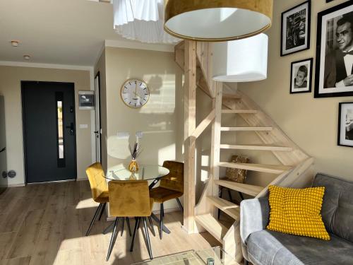 a living room with a staircase and a table and chairs at Casa Kashubia - Nowoczesny dom wakacyjny nad jeziorem - Cisza natura i komfort in Brzeźno Szlacheckie