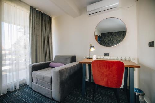 a room with a couch and a table and a mirror at VILA RADOVIC ROOMS AND APARTMENTS in Kragujevac
