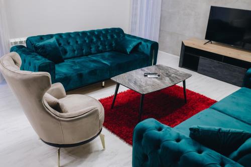 uma sala de estar com um sofá verde e uma mesa em VILA RADOVIC ROOMS AND APARTMENTS em Kragujevac