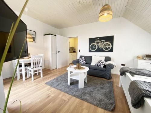 una sala de estar con un sofá y una mesa en Ferien im Wangerland - Haus Wiesenweg - Apartment 2 1OG, en Horumersiel