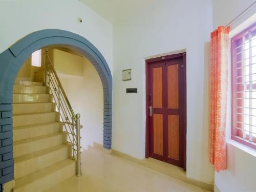 pasillo con escalera y puerta en OYO Flagship Aiswarya Residency, en Wayanad