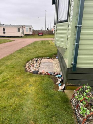 a small rock garden next to a house at Red Lion Caravan Park, Arbroath in Arbroath