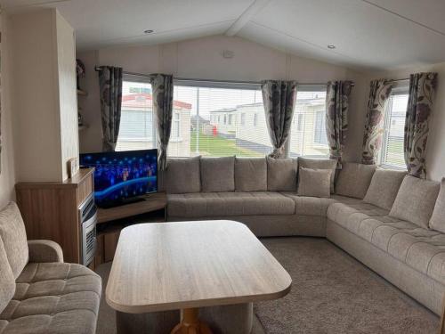 uma sala de estar com um sofá e uma mesa em Red Lion Caravan Park, Arbroath em Arbroath