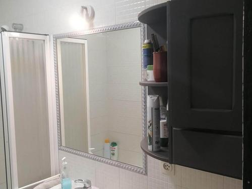 uma casa de banho com um espelho grande e um lavatório em Cosy apartment with shared balcony em Sevilha