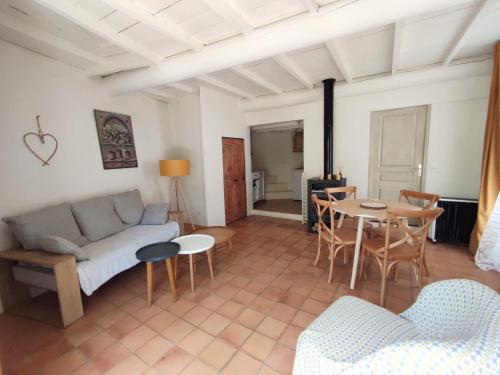 uma sala de estar com um sofá e uma mesa em Charmante maison de village Proche d'Uzès em La Bruguière