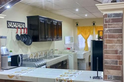 a kitchen with a sink and a stove at Casa Villa Flores in San Martín Zapotitlán