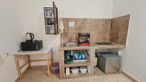 a kitchen with a counter with a sink and a stove at Departamento Añil in San Antonio de la Cal
