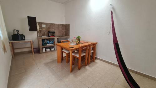 a table and chairs in a room with a kitchen at Departamento Añil in San Antonio de la Cal