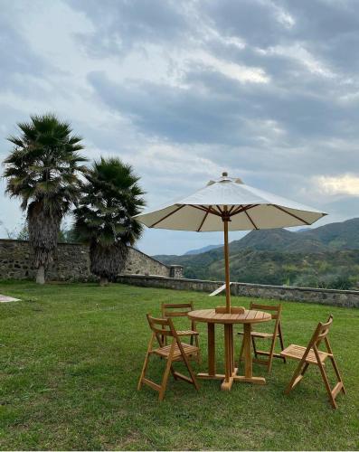 - une table de pique-nique et des chaises avec un parasol dans l'établissement Villa Mipa, à Pueblo Bello