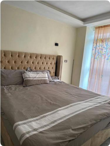 a large bed in a bedroom with a window at Condo near to the airport, beside Shola supermarket and close to Megenagna square in Addis Ababa