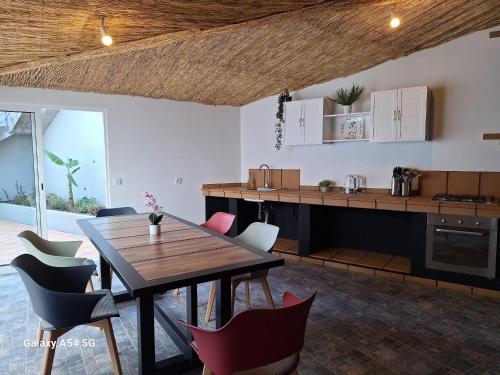 kuchnia i jadalnia z drewnianym stołem i krzesłami w obiekcie Figueira's House By the Atlantic w mieście Ponta do Sol