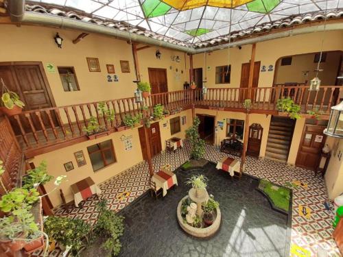 une cour intérieure avec des chaises et des plantes en pot dans un bâtiment dans l'établissement Casa Bonita Colonial, à Cajamarca