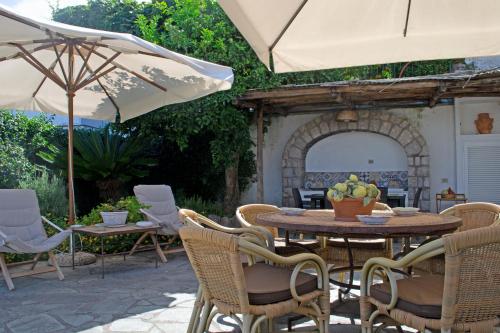 a patio with a table and chairs and an umbrella at Casa il Terrazzino in Anacapri