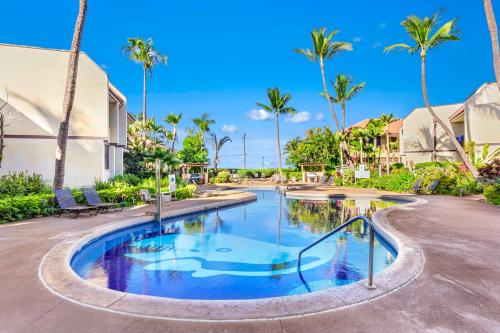 a swimming pool at a resort with palm trees at Maui Beach Vacation Club in Kihei