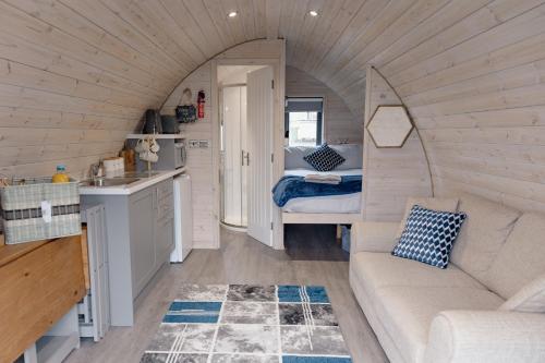 ein Wohnzimmer mit Sofa und Bett in einem winzigen Haus in der Unterkunft Coolaness Glamping in Irvinestown