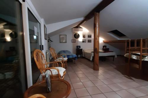 ein Wohnzimmer mit einem Bett, einem Tisch und Stühlen in der Unterkunft La Soffitta di Maria in La Spezia