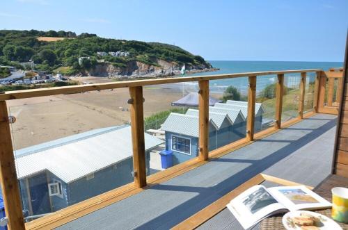 a balcony with a view of the beach at Pabell Pren Glamping by Aberporth Beach Holidays in Aberporth