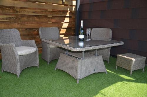 a table and chairs and a bottle of wine on a patio at Pabell Pren Glamping by Aberporth Beach Holidays in Aberporth