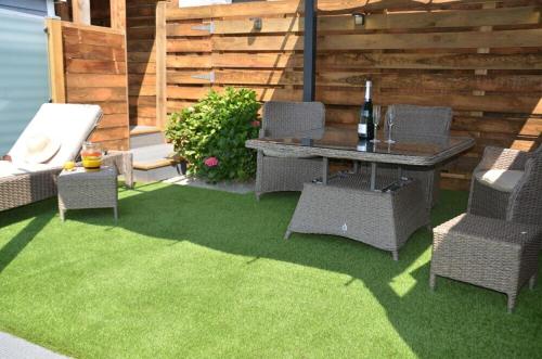 a patio with a table and chairs on grass at Pabell Pren Glamping by Aberporth Beach Holidays in Aberporth