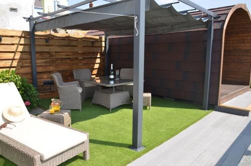 a pergola with a table and chairs on a lawn at Pabell Pren Glamping - by Aberporth Beach Holidays in Aberporth