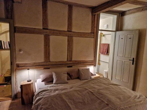 Schlafzimmer mit einem großen Bett mit einem Kopfteil aus Holz in der Unterkunft allio - das turmchalet in Berching