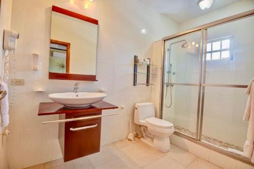 a bathroom with a toilet and a sink and a shower at 4C's Vacation Suites in Lower South Hill