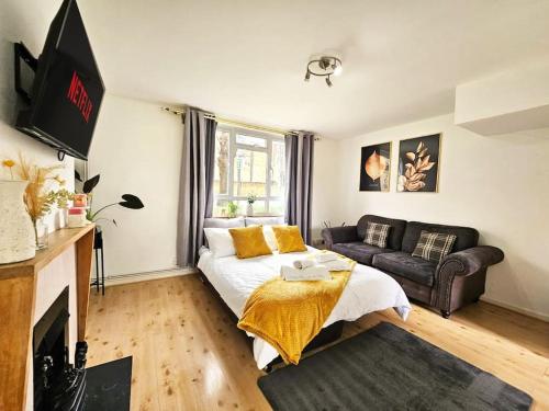a living room with a bed and a couch at Golden Stay flat next to Camden Town in London