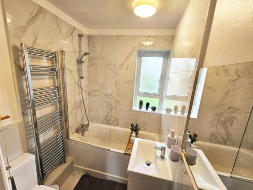 a bathroom with a tub and a sink and a shower at Golden Stay flat next to Camden Town in London