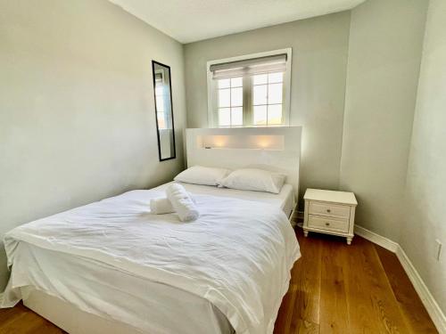 a bedroom with a large white bed and a window at House In Scarborough 20 Minutes to Downtown in Toronto