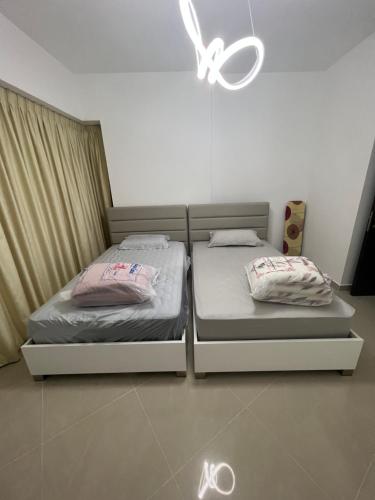 two beds sitting next to each other in a bedroom at The blue residence in Abu Dhabi