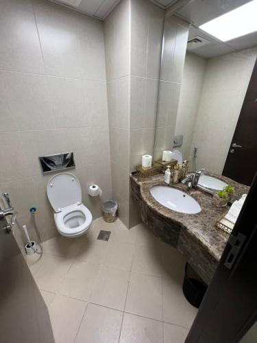 uma casa de banho com um WC e um lavatório em The blue residence em Abu Dhabi