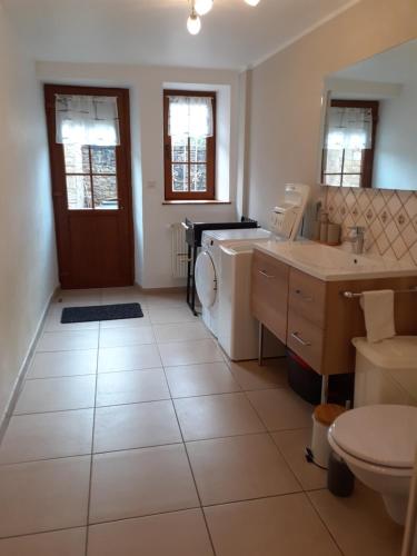 a bathroom with a sink and a washing machine at A l'OREE DU BOIS in Ville-Houdlémont