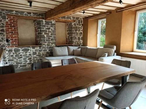 sala de estar con mesa de madera y sillas en Ancienne ferme totalement rénové moderne à Baelen, en Baelen