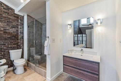 a bathroom with a toilet and a sink and a shower at Beltline Beauty*Mins to Benz Stadium, Game Room* in Atlanta